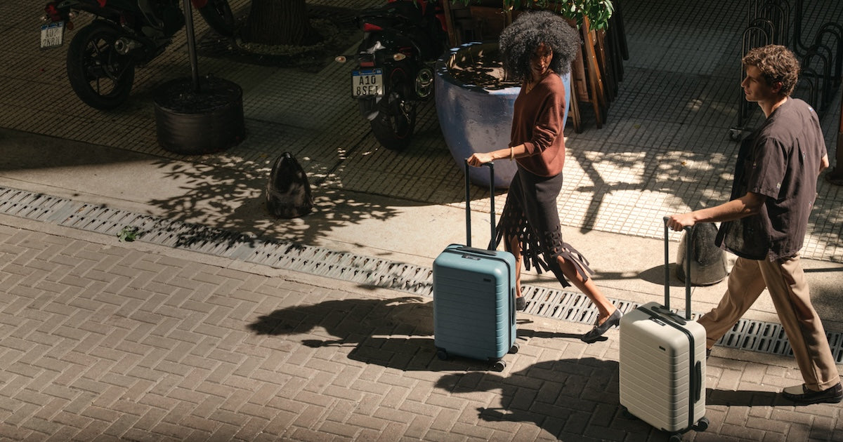 Two travelers rolling Away suitcases